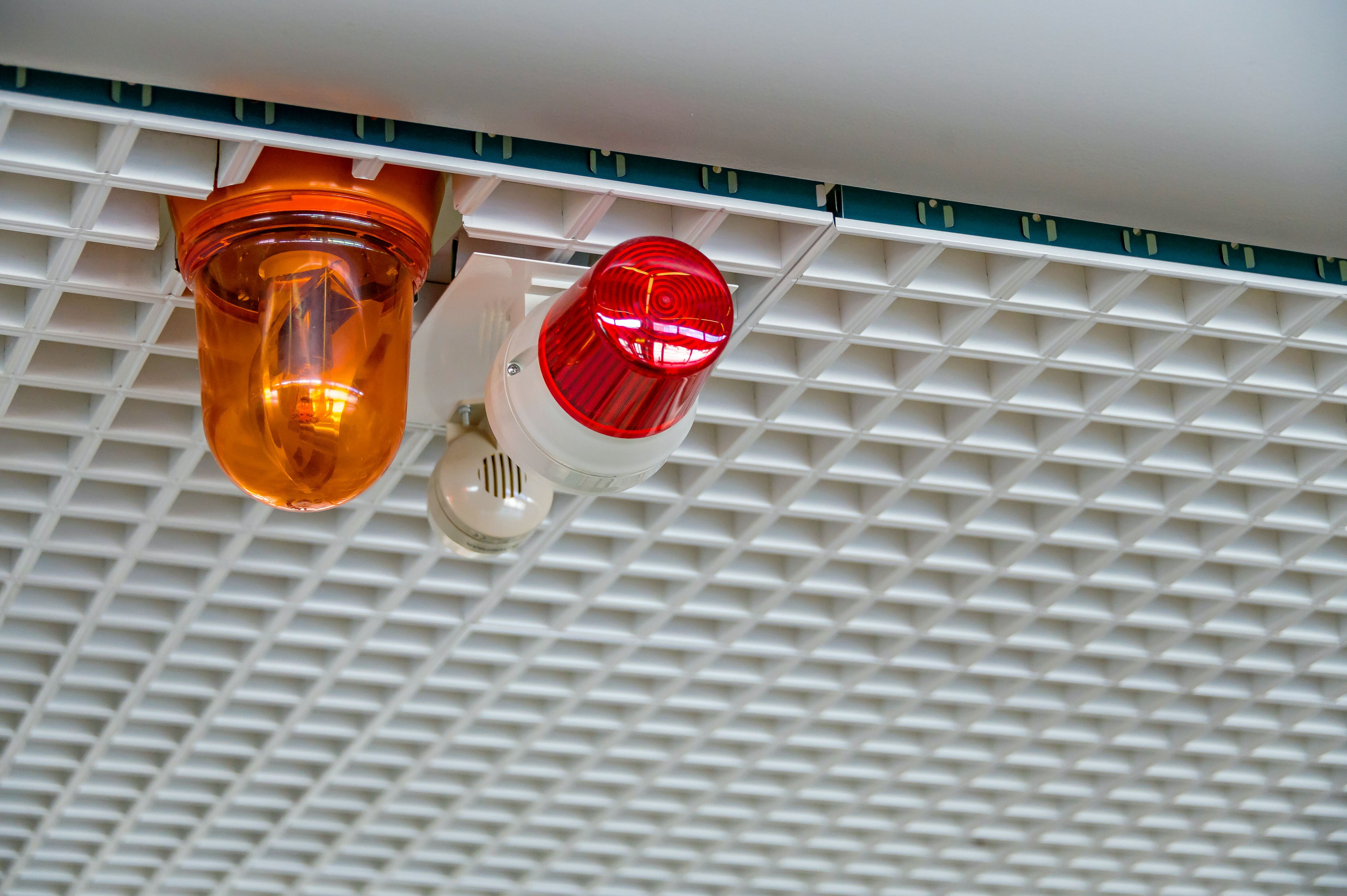Foto av varsellamper og sirene for nødvarsling montert i tak innendørs. Illustrasjonsbilde.